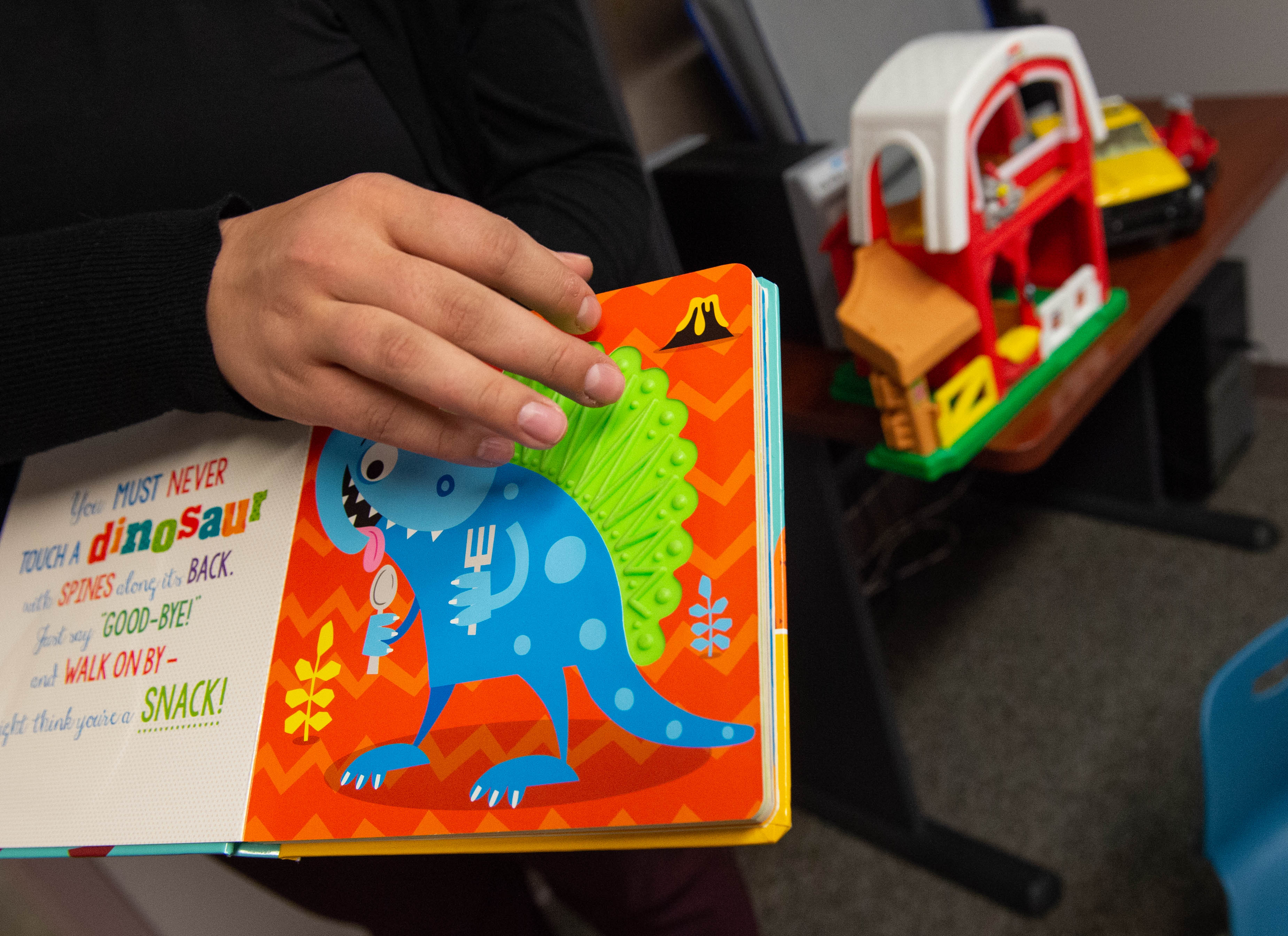 Photo of a woman's hand holding a children's book