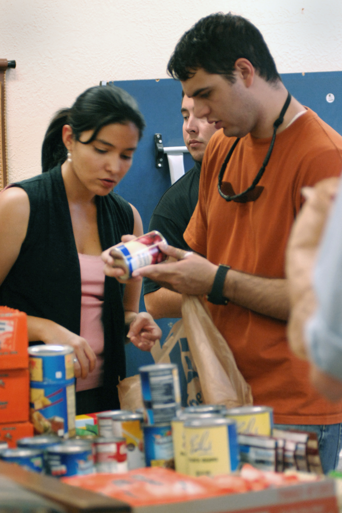 Haussamen and volunteer in orange sorting donations
