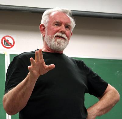 Alvy Ray Smith, Pixar co-founder and NMSU alumnus, gestures while standing in front of a chalkboard.  