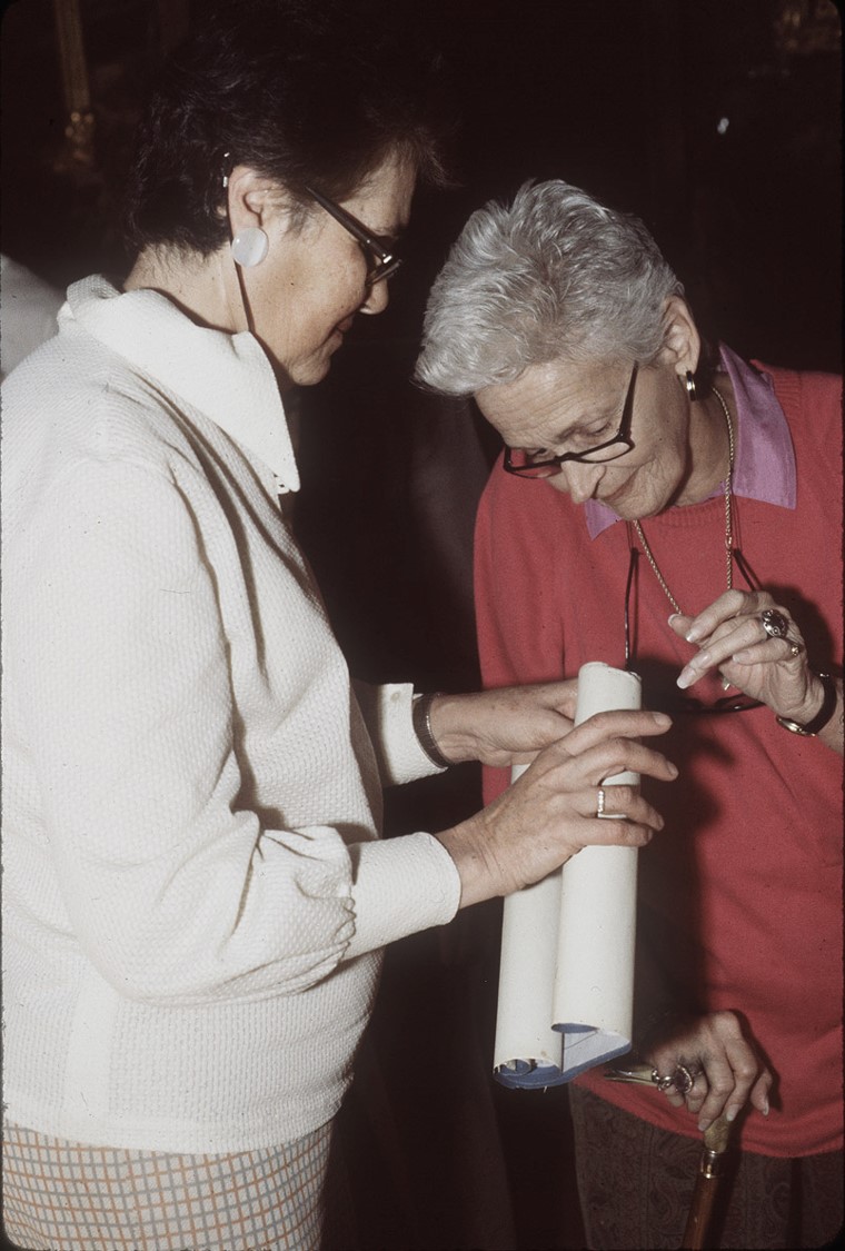 Two women looking at a document. 