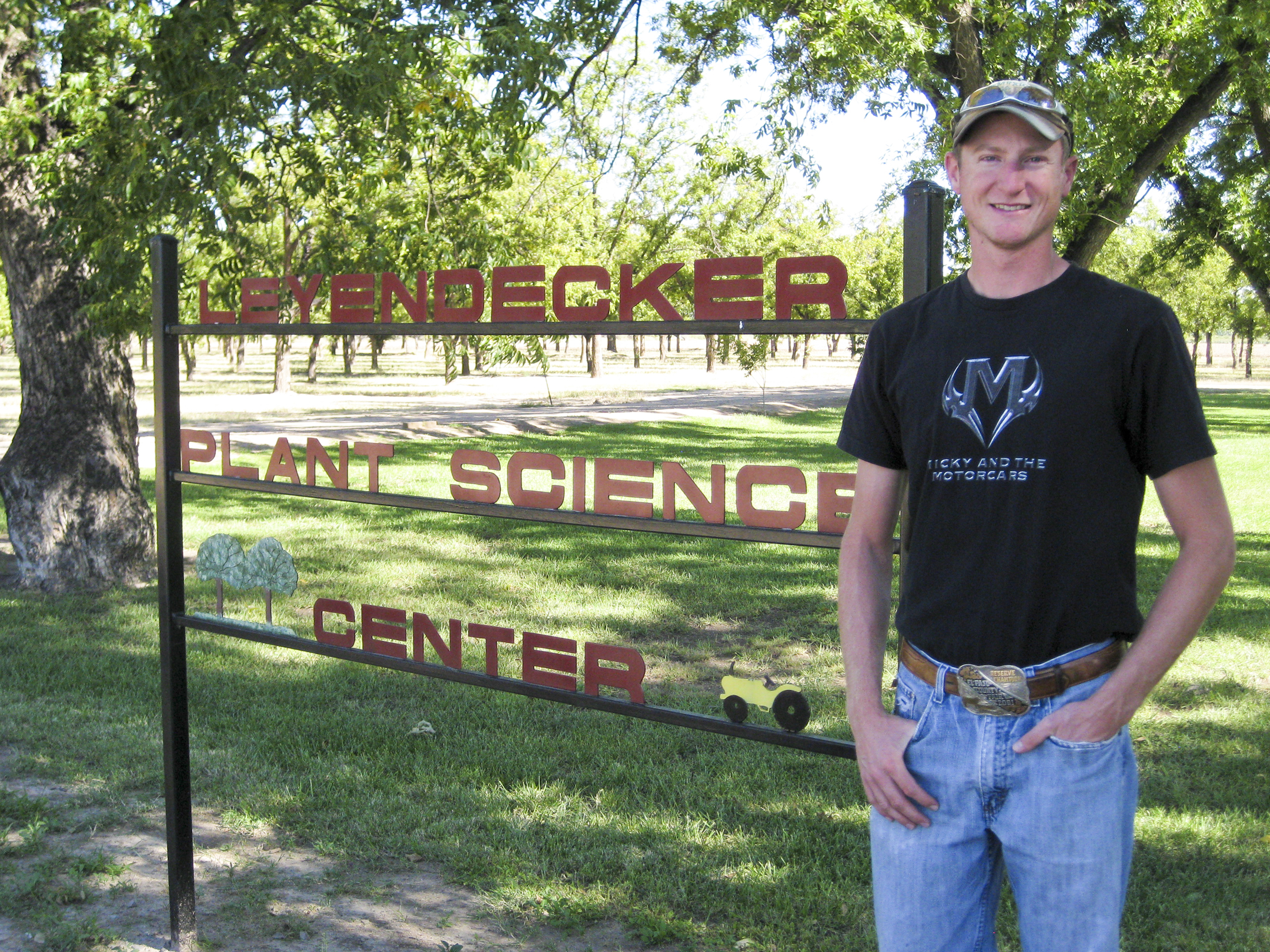 Dave Lowry stands next to the Leyendecker Plant Science Center sign.