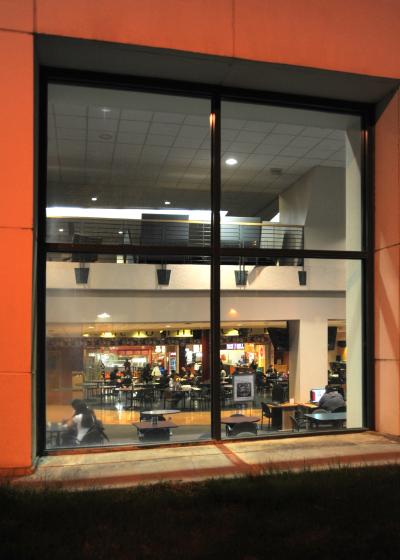 This photo was taken at night, looking through an exterior Corbett Center Student Union window toward the food court. 