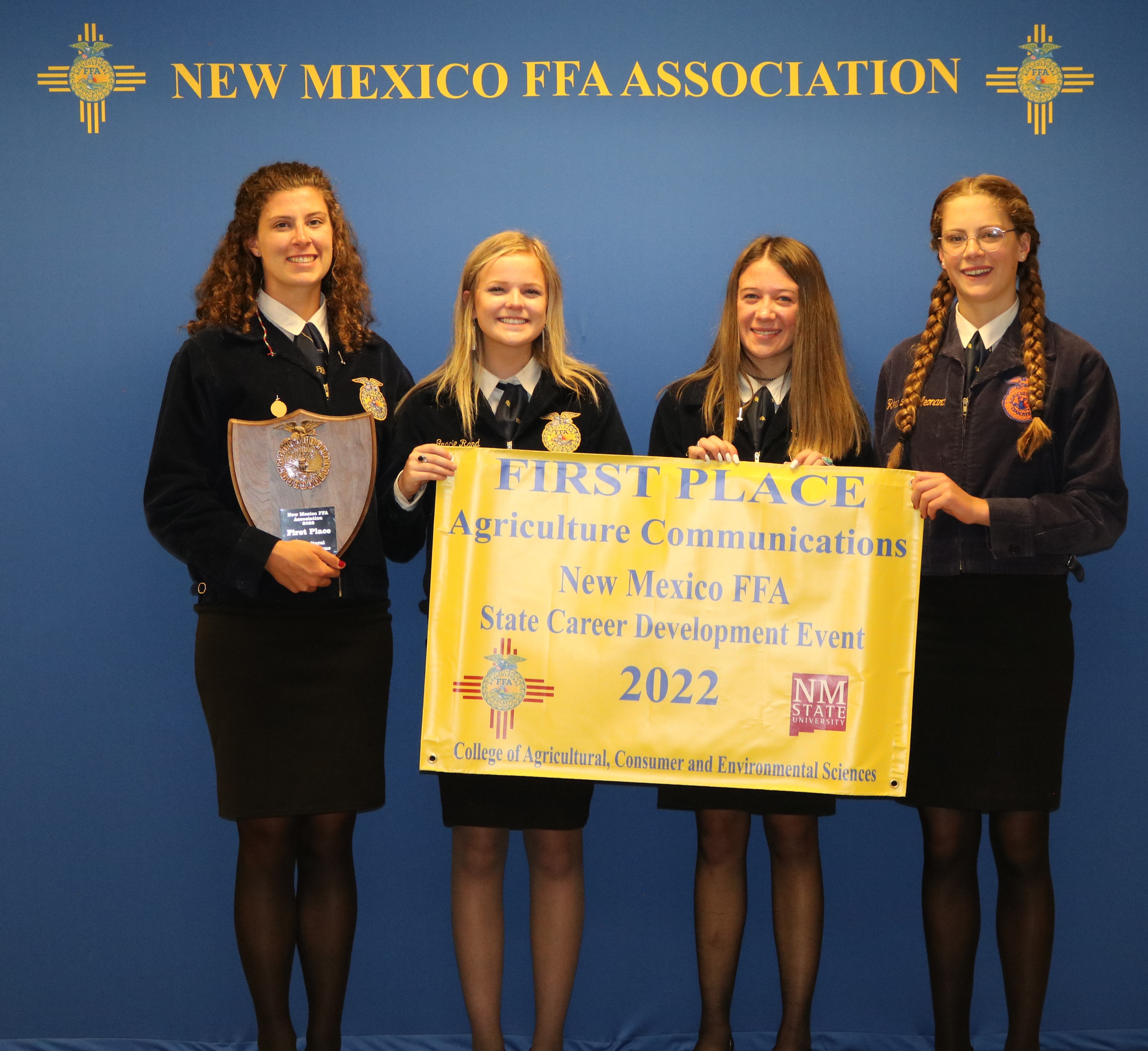 Four young women hold a banner for wining first place. 