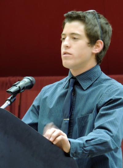 A young man speaks from a podium.