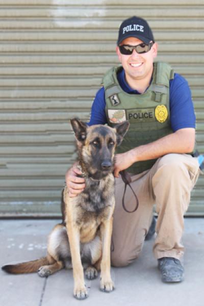 A New Mexico State University police officer poses with his canine partner. 