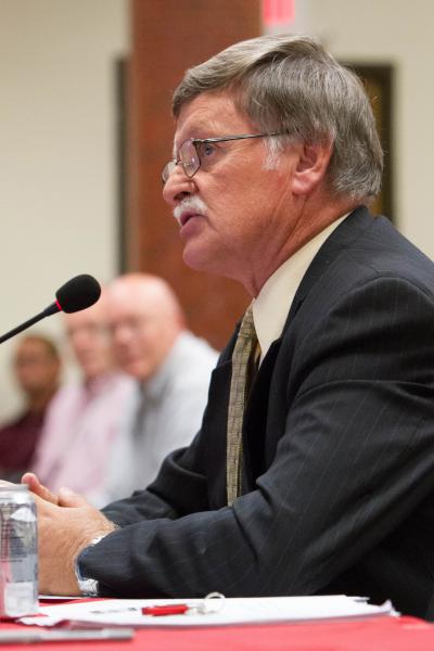 NMSU Carlsbad President John Gratton sitting at a table speaking to the Board of Regents. 