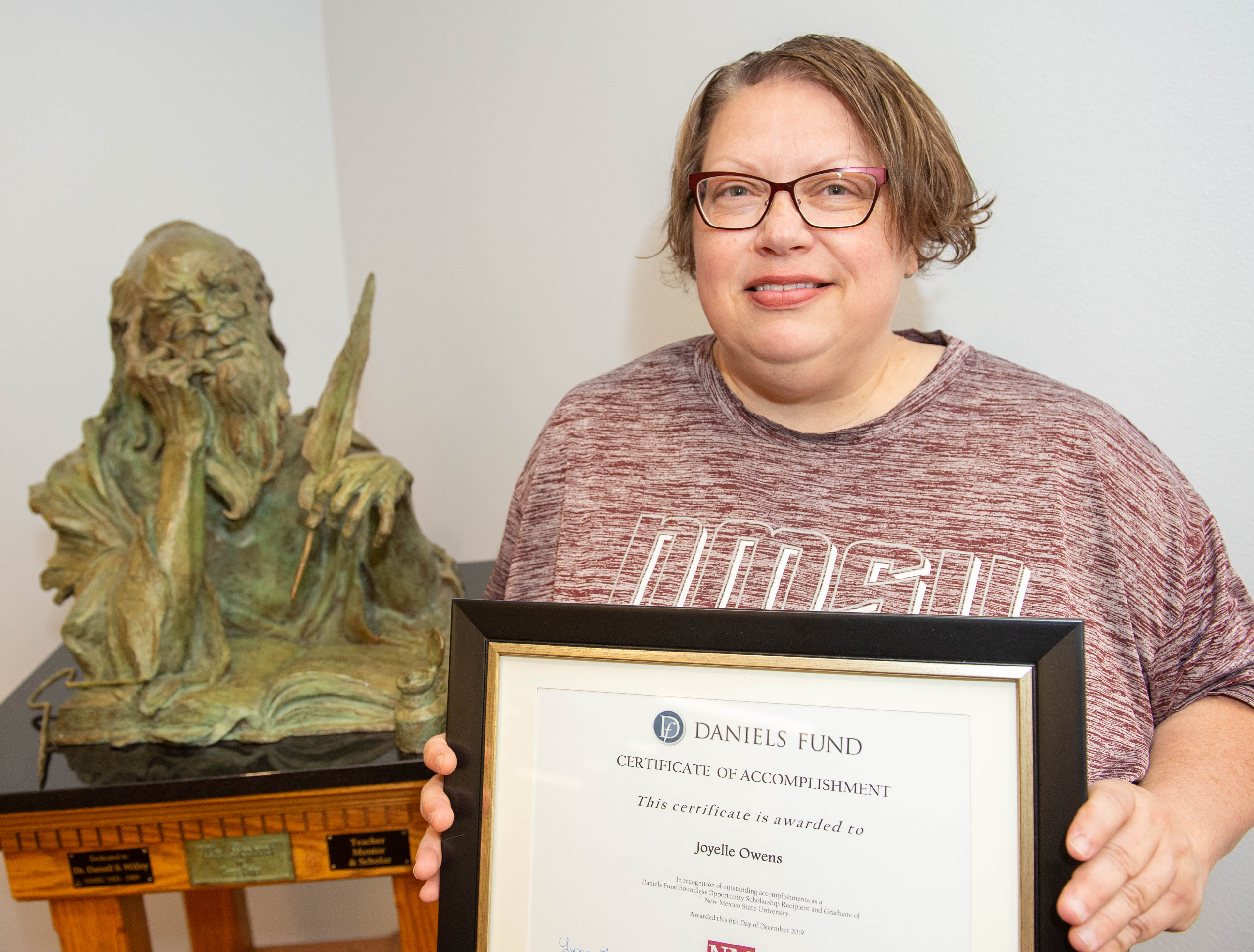 Woman holds a framed certificate