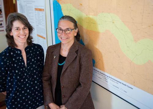 Two women standing in front of a map