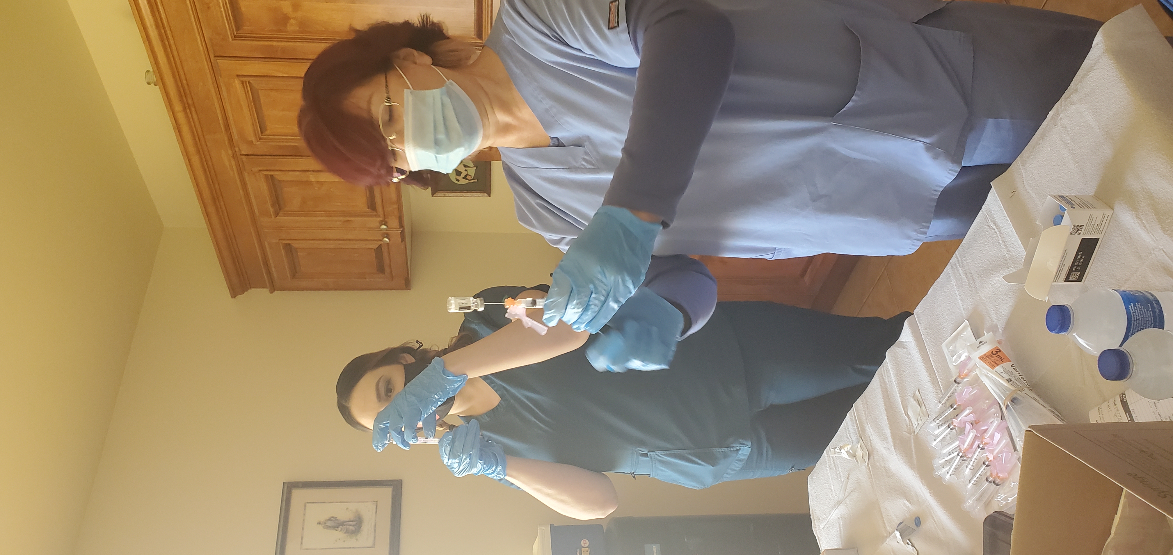 Two women standing and preparing vaccinations.
