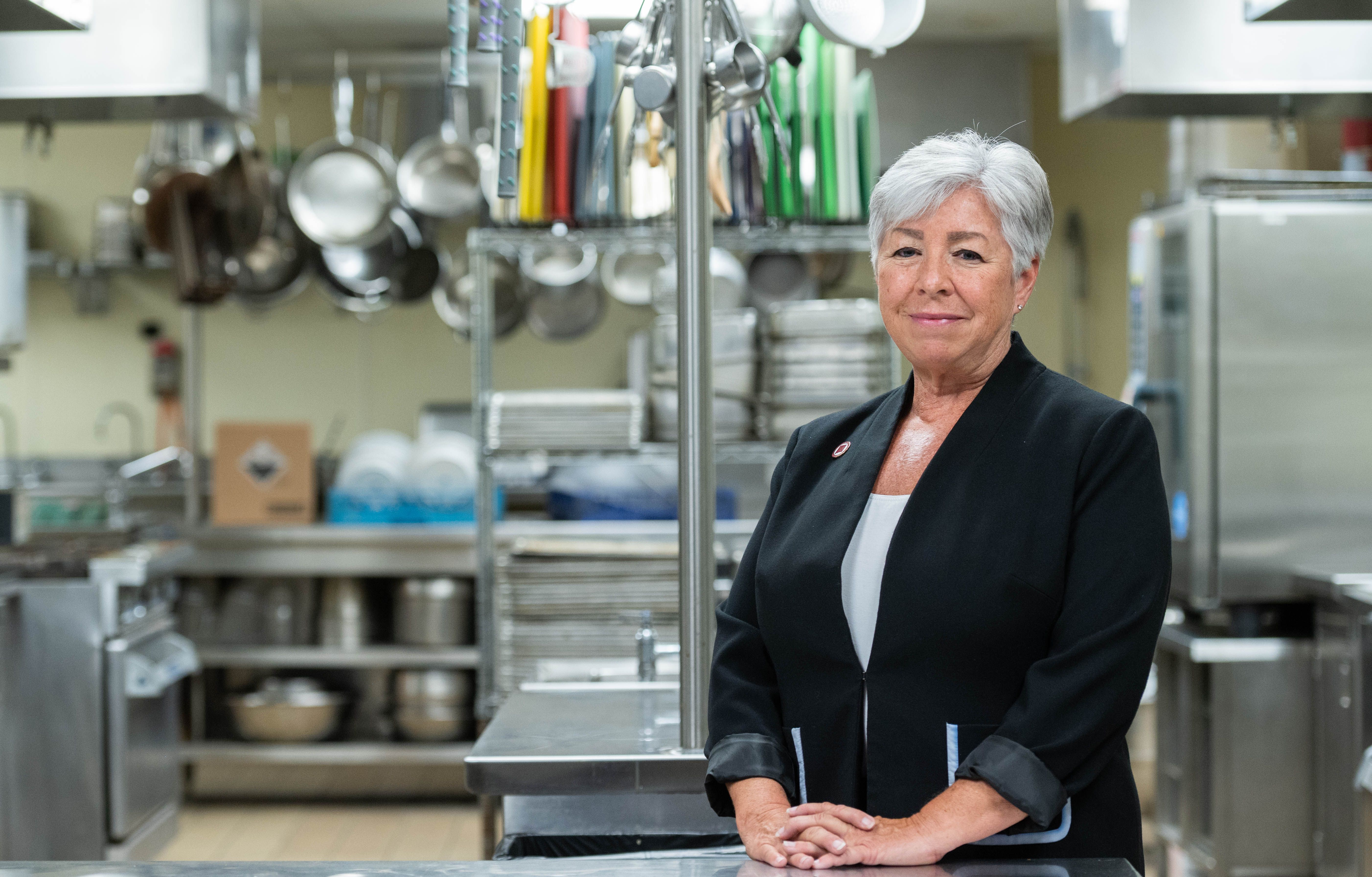 Woman stands in kitchen