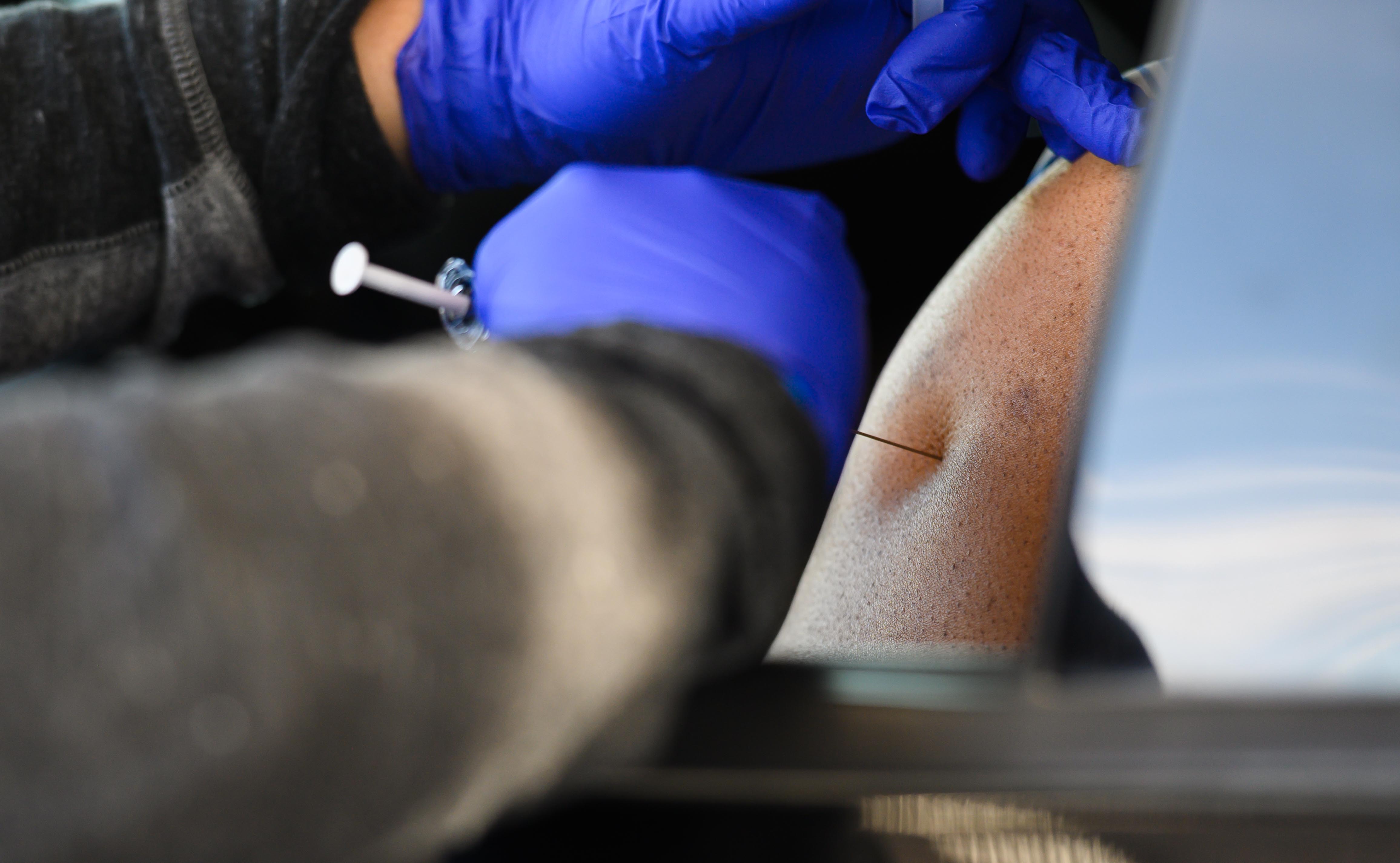 Close up image of a person receiving a vaccine in an arm.