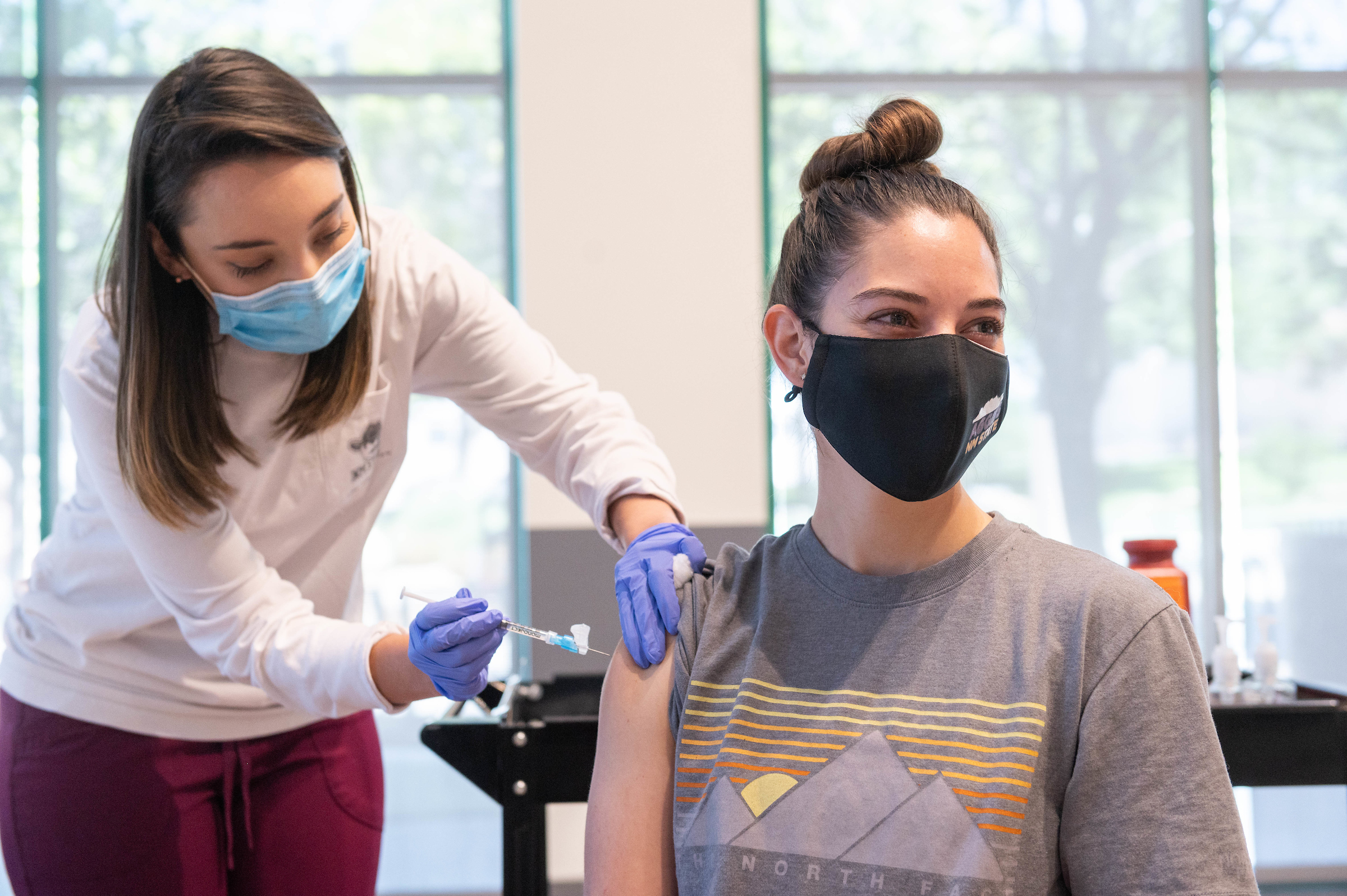 Masked woman receiving vaccine shot