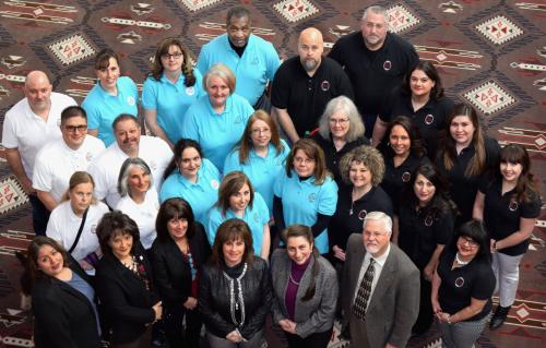Large group of people in white, black and turquoise shirts