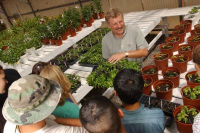 Paul Bosland shows young chile plants to a group of students.