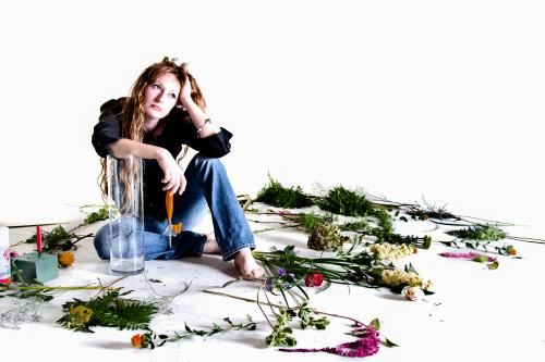 Woman poses with flowers.