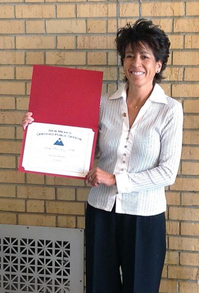 Woman holding certificate out to her side