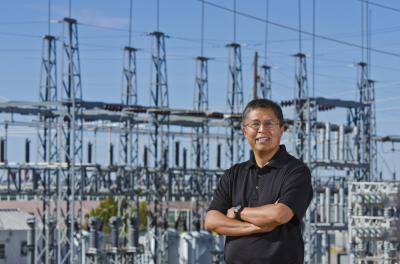 Man standing in front of electrical substation