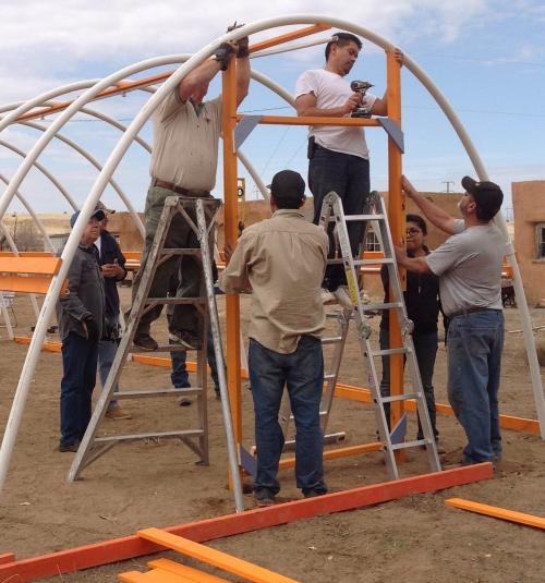 People building a hoop house structure