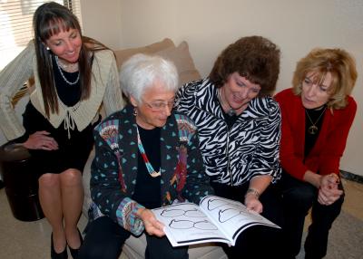 four women looking at a book