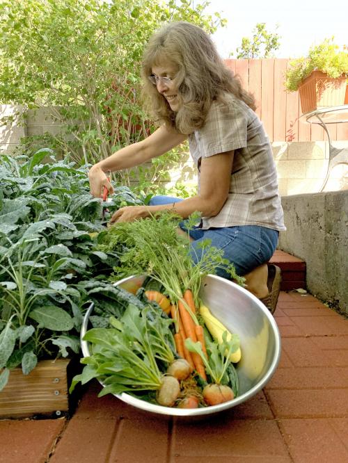 Woman sitting with basket of vegetables.
